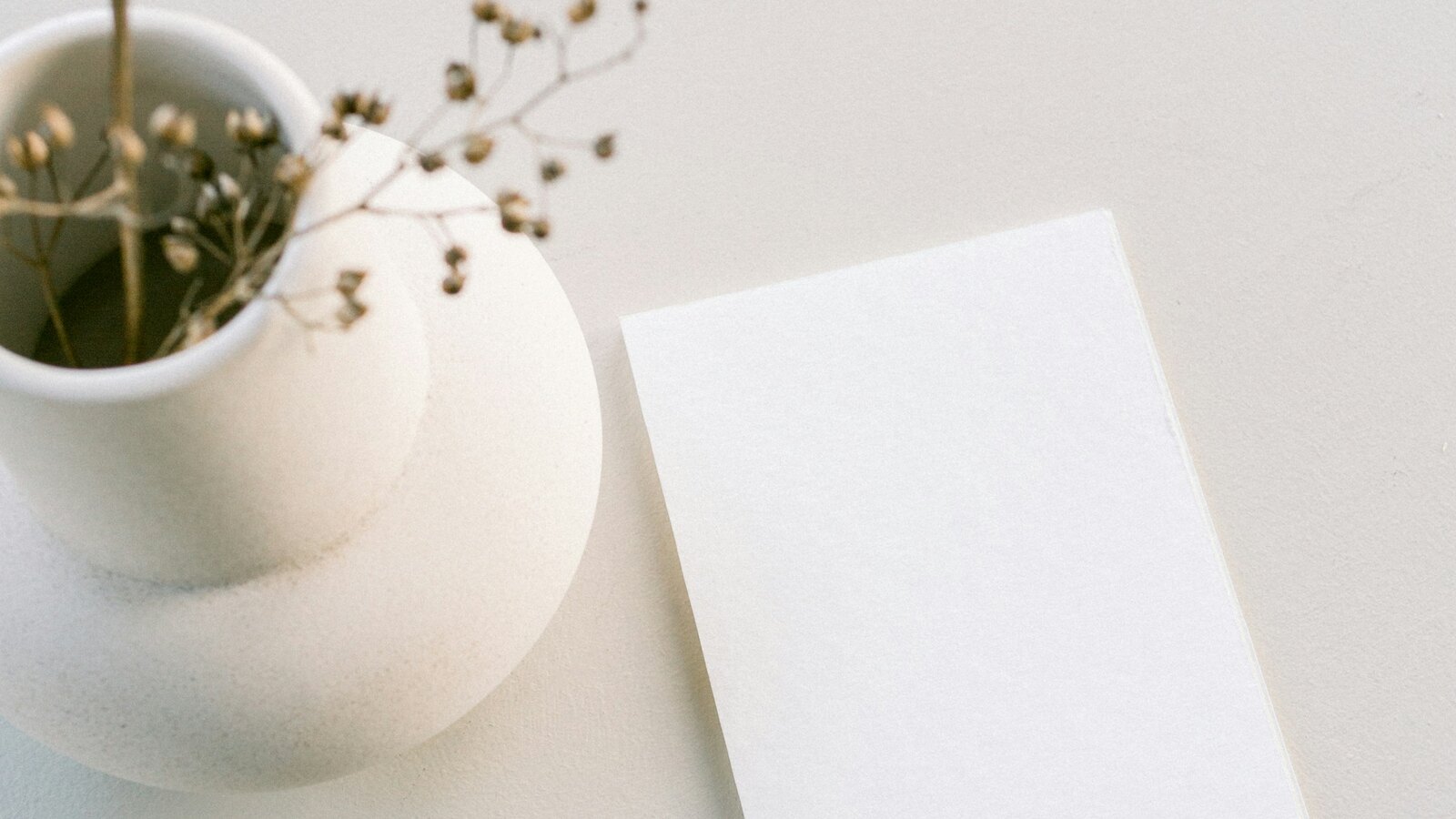 Wedding stationery and an envelope laid out in neutral tones