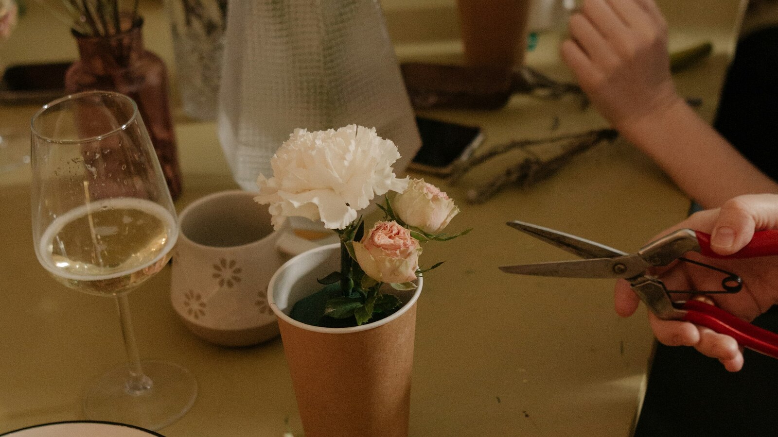 A florist arranging wedding flowers in a workshop