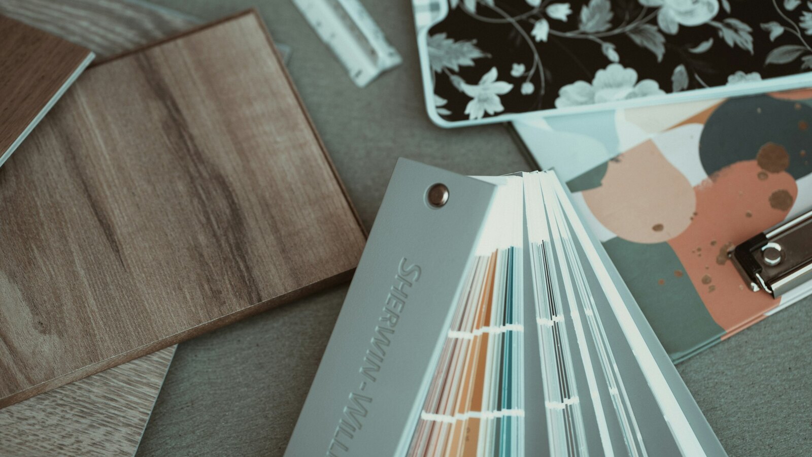 A planner desk with flowers and fabric samples in neutral tones